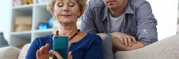 Пожилая женщина сидит на диване