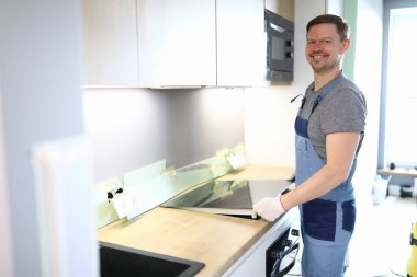 Adam yeni mutfak mobilyaları ve aletleri kuruyor.