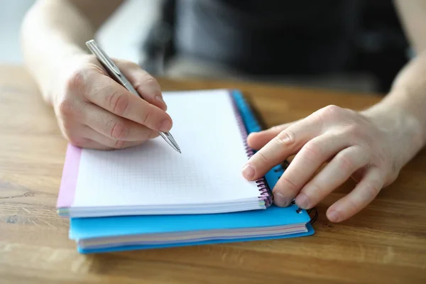 Hands make notes in a notebook on a wooden table — Stock Photo, Image
