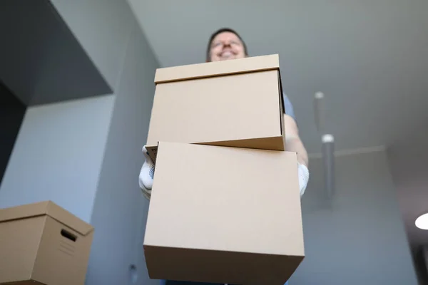 A loader in an empty room holds a cardboard — Stock Photo, Image