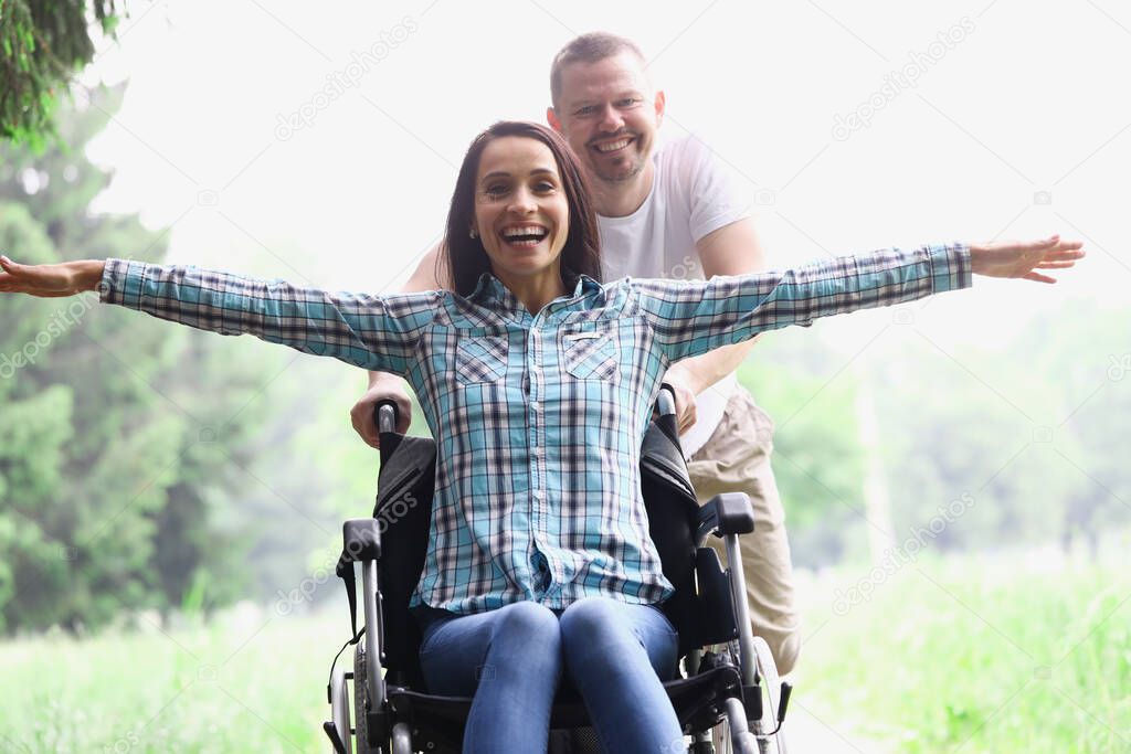 A young woman is sitting on a wheelchair in forest