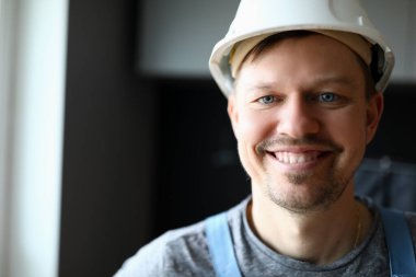 İş yerinde miğfer takan mutlu yüz yapıcı.