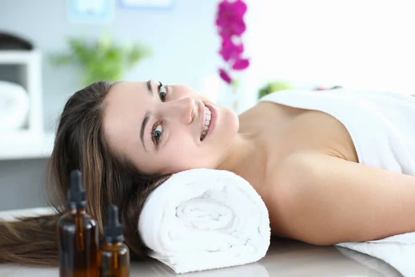 A mulher está em uma sala de massagem e sorri — Fotografia de Stock