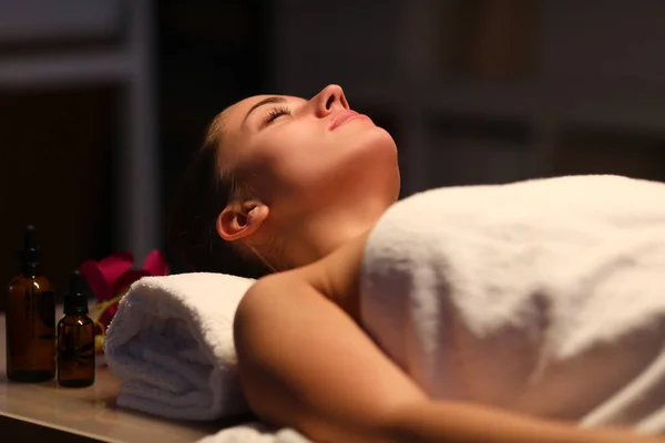 Mooie vrouw in een handdoek ligt in een massage kamer — Stockfoto