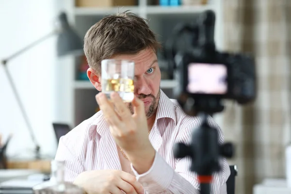 수염이 있는 남자가 카메라 앞에서 유리를 보여 주고 있다 — 스톡 사진