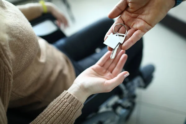 Молода жінка на інвалідному візку приймає ключі від будинку — стокове фото