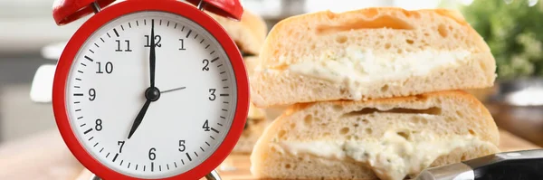 Mesa un reloj despertador y desayuno pan y salsa — Foto de Stock