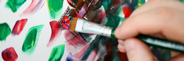 Mãos segurando escova com tinta multi-colorida — Fotografia de Stock