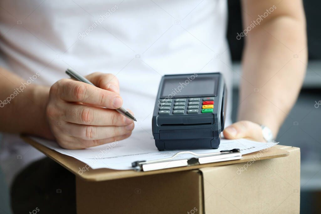 Male hand sign order receipt close up and pay by terminal.