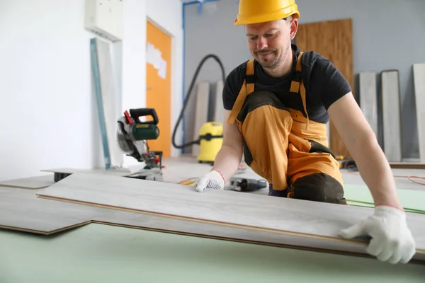 Specialist hold laminate in his handand put it on floor. — Stock Photo, Image