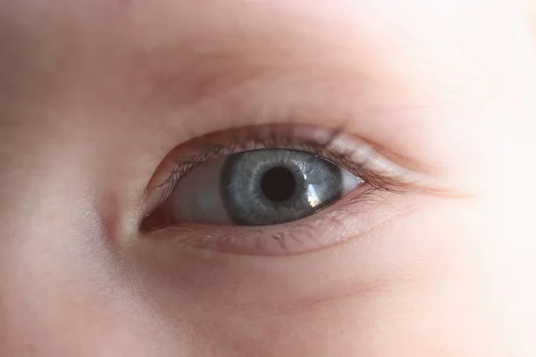 Young girls eye with blue pupil closeup — Stock Photo, Image