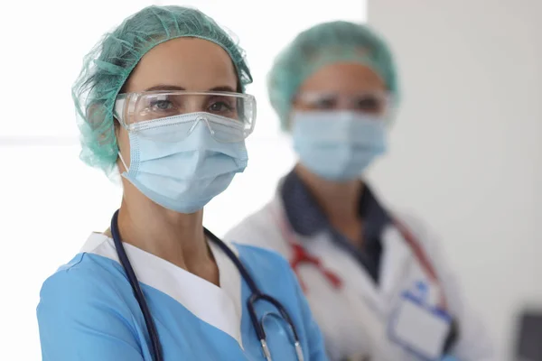 Portret van twee artsen in beschermende medische maskers, bril en handschoenen — Stockfoto