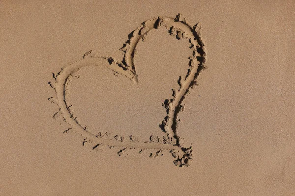 Coeur dessiné sur le sable par fond de gros plan de mer — Photo