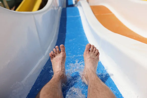 Мужские ноги на фоне американских горок в аквапарке крупным планом — стоковое фото