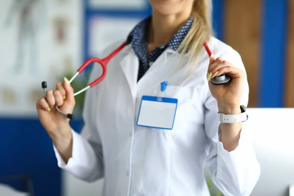 Ufficiale medico in mantello bianco tiene stetoscopio. — Foto Stock