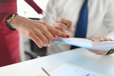 Erkekler dizüstü bilgisayarı elinde tutarken yanında bir kadın durur ve işaret eder..