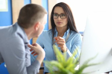 İş kadını ve işadamı iş süreçlerini tartışıyor.