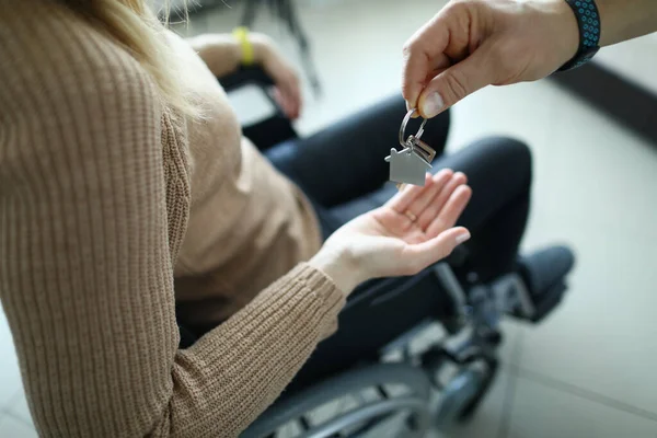 Mulher está sentada em cadeira de rodas e as chaves são entregues a ela. — Fotografia de Stock