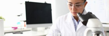 Laboratuvar asistanı kimyasal analiz yapıyor.