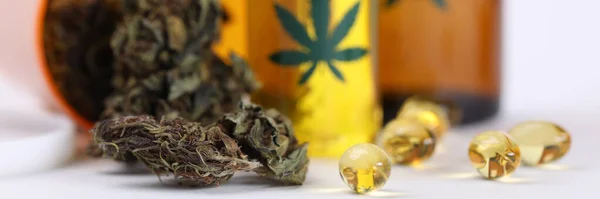 Auf dem Tisch Marihuana im Glas und Hanföl in Kapseln — Stockfoto