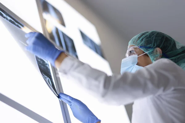 Γυναίκα γιατρός εξετάζει ακτινογραφία του ασθενούς στο χειρουργείο — Φωτογραφία Αρχείου