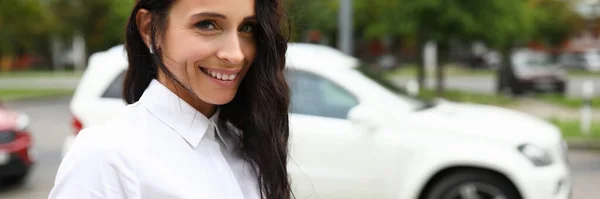Mulher de camisa branca fica na rua e sorri — Fotografia de Stock