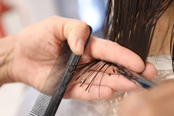 女性手用剪刀剪头发，拿着梳子. — 图库照片
