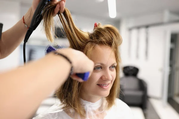 Cabeleireiro fazer estilo de cabelo com secador de cabelo e pente. — Fotografia de Stock