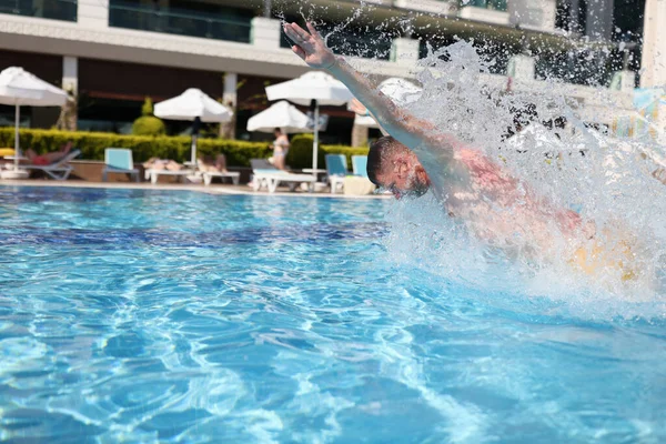 Hombre nadando con golpe de pecho en piscina azul de agua clara. — Foto de Stock