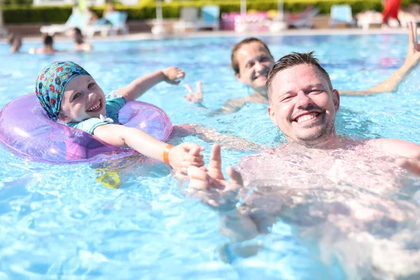 Boldog család úszni medencében kék átlátszó víz. — Stock Fotó