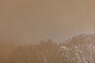 Yumuşak kum ve kabarcıklı berrak su.