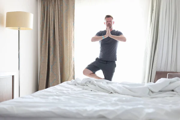 Чоловік робить ранкові вправи в кімнаті і медитує . — стокове фото