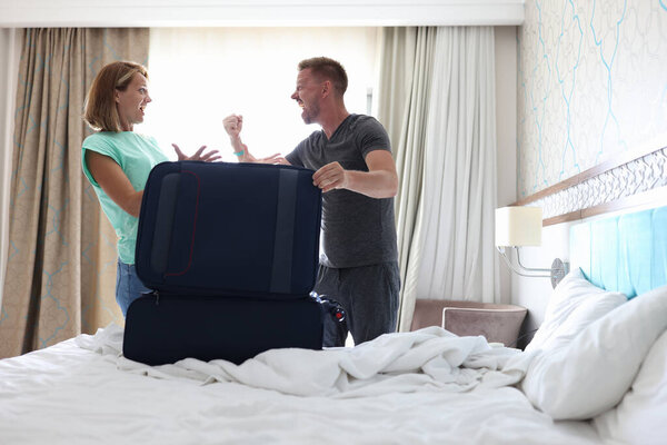 Angry man hold lid of suitcase shout and show his fist.