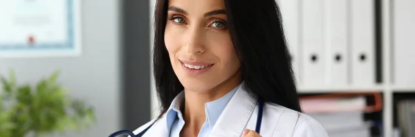 Довольно взрослая белая женщина-терапевт, растягивающая стетоскоп в руках — стоковое фото