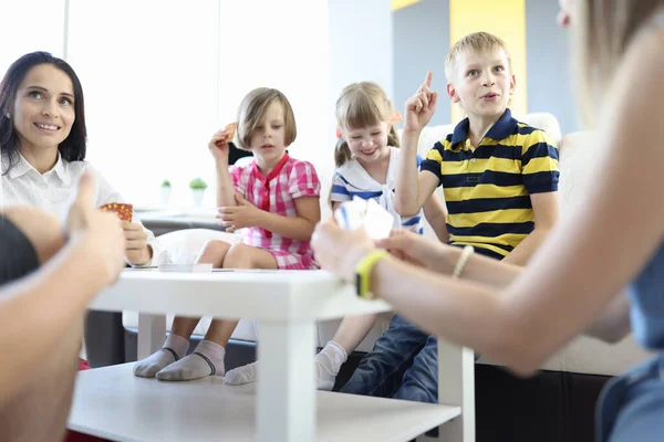 Volwassenen en kinderen spelen samen bordspellen thuis. — Stockfoto