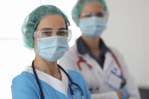 Twee artsen in brillen en beschermende medische maskers staan in functie — Stockfoto