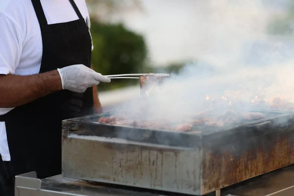 On street gloved chef prepares barbecue closeup