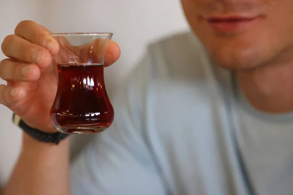 Mans Hand hält Glas mit dunkler Flüssigkeit in den Händen. — Stockfoto