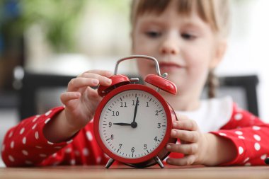 Arka plandaki küçük kız elinde sabahları kırmızı alarm düğmesine basıyor.