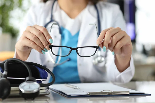 Läkare med stetoskop och apparat för att byta tryck med glasögon i händerna på kontoret närbild — Stockfoto