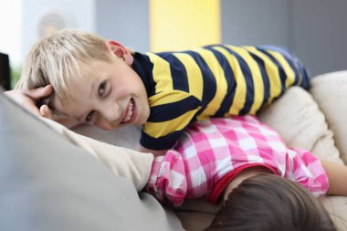 Mutlu çocuklar kanepede oynuyor..