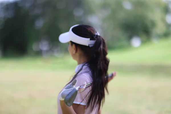 Mujer mantenga palo de golf en sus manos y mirar a la distancia. — Foto de Stock