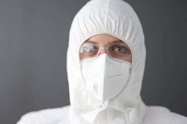 Koruyucu antiveba giysisi, gözlük ve solunum portresi giyen doktor.