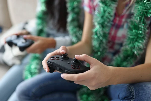 Dos mujeres con oropel alrededor de sus cuellos están sosteniendo joysticks primer plano —  Fotos de Stock