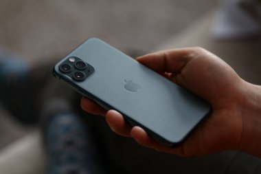 Bir adam yeni model bir Apple iphone 'u yakından tutuyor.