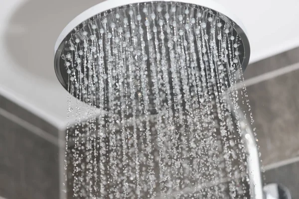Close-up de fluxos de água em pequenos jatos de chuva de metal chuveiro no banheiro — Fotografia de Stock