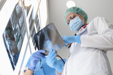 Doktorlar bunu tartışırken röntgeni incelerler..