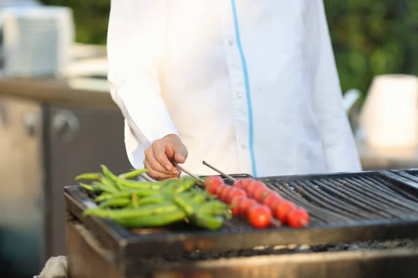 Cook készíti zöld paprika és paradicsom brazier kívül — Stock Fotó