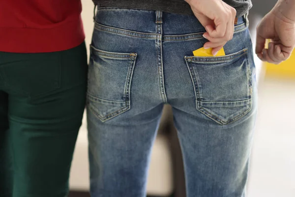 Woman take yellow condom out of pocket, back view. — Stock Photo, Image