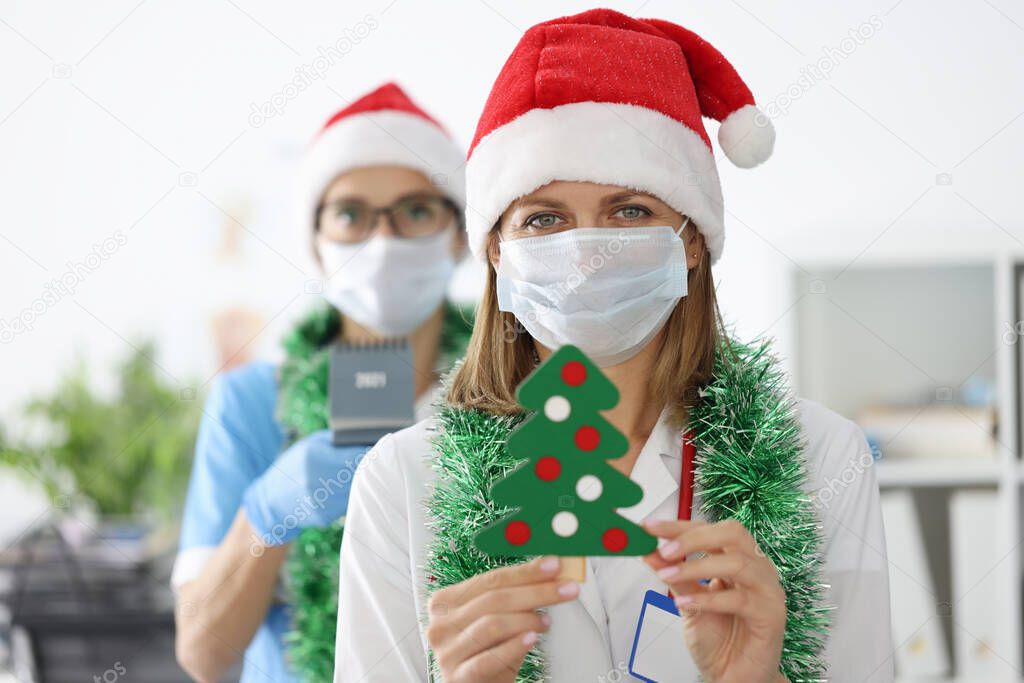 Doctor in white coat hold paper tree with decoration.